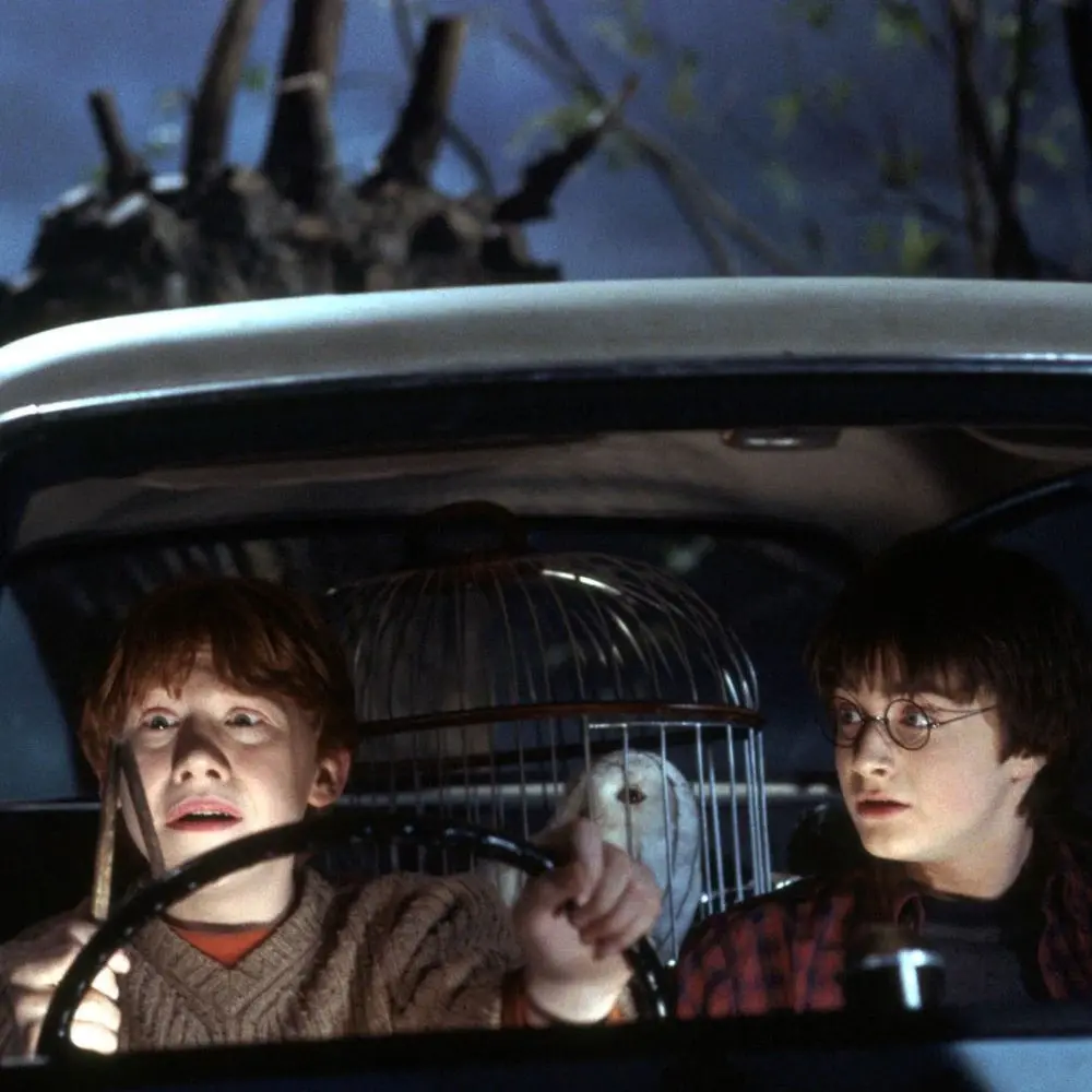 Harry Potter e Rony Weasley voando em um carro voador no filme Harry Potter e a Camara Secreta